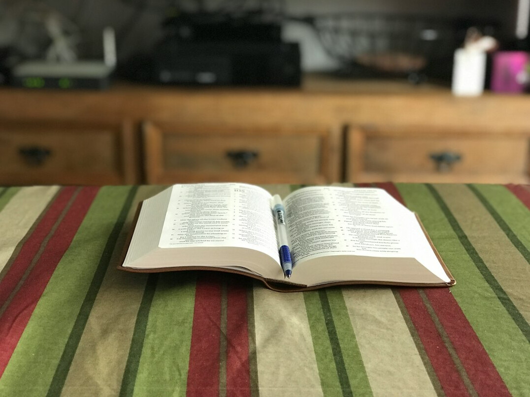 Open book with a pen resting on its pages