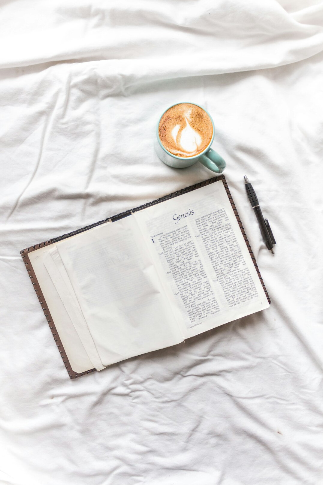 Open notebook with a pen and a cup of coffee